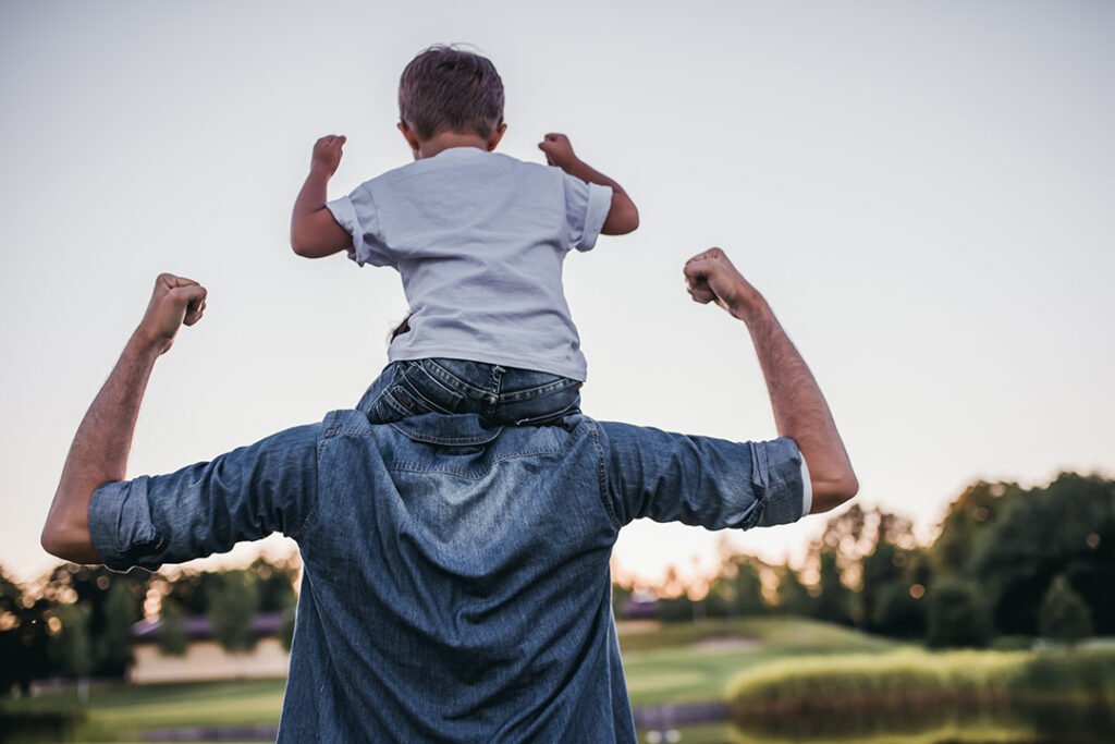 Father and son flexing their muscles