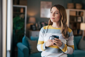 Woman drinking coffee in her living room