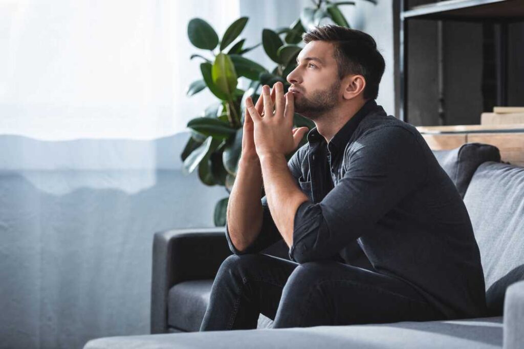 man sitting on his sofa deep in thought