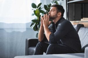 man sitting on his sofa deep in thought