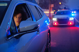 Woman looks at patrol car in rear view mirror